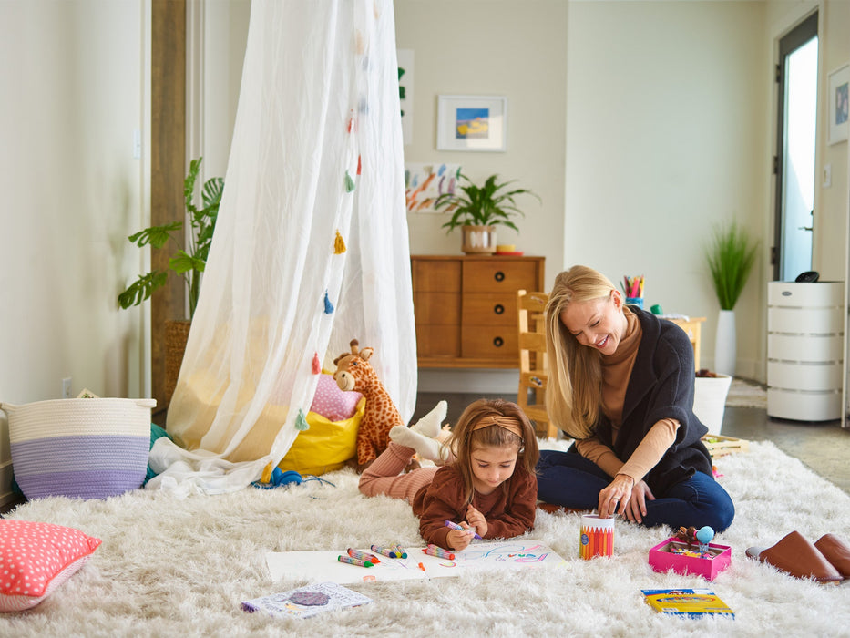 Woman playing with child with Carrier Smart Room Air Purifier in the background